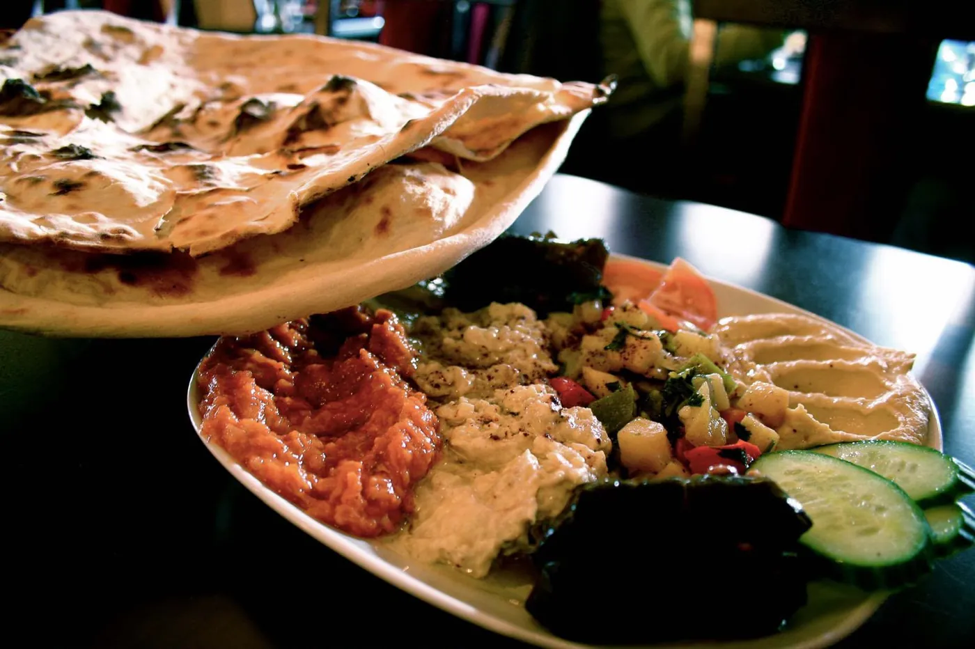 Mezze of hummus, moutabal and vine leaves with warm bread
